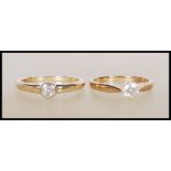 Two hallmarked 9ct yellow gold single stone solitaire diamond rings. One ring having a prong set