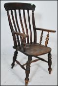 A 19th Century Victorian Windsor beech and elm wood arm chair raised on turned supports united by