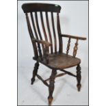 A 19th Century Victorian Windsor beech and elm wood arm chair raised on turned supports united by