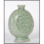A 19th Century Chinese ceramic bottle / moon flask having a green glaze finish with floral relief