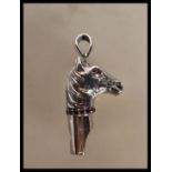 A silver novelty whistle pendant in the form of a horse head set with ruby eyes and having a ruby