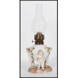 A 19th Century German Sitzendorf floral encrusted winged cherub / putti porcelain oil lamp set