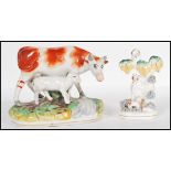 A 19th Century early Staffordshire flat back figurine in the form of a cow with a lamb together with
