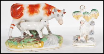 A 19th Century early Staffordshire flat back figurine in the form of a cow with a lamb together with