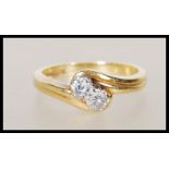A hallmarked 18ct yellow gold ring having a crossover mount set with round cut diamonds of approx