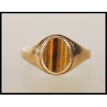 A 9ct gold ring set with an oval tigers eye panel to the head. Marks rubbed. Weight 3.8g. Size T.