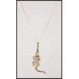 A 9ct gold hallmarked pendant modelled as a Crocodile inset with diamonds set on a fine 9ct gold