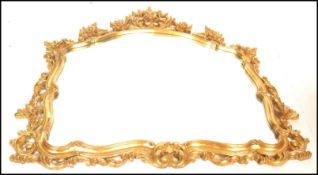 A contemporary gilt overmantle wall mirror, in the Rococo taste central mirrored panel surrounded