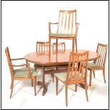 A G plan teak D end extending dining table with fold out central leaf over a plain frieze and