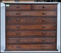 A early 20th Century stain pine specimen chest of drawers. Raised on a plinth base having two