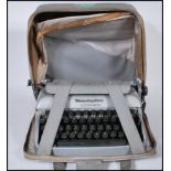 A mid 20th Century vintage Remington Travel-Riter portable typewriter having a grey enamel finish