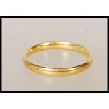 A hallmarked 22ct gold wedding band ring. Hallmarked Birmingham (date marks rubbed). Weight 2.6g.