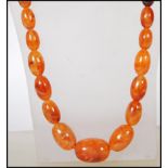 A vintage early 20th Century amber coloured bakelite graduating beaded necklace. Measures approx