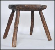 A 19th Century country rustic primitive elm rectangular milking stool, plank top raised on four