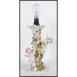 A 20th Century German porcelain Sitzendorf table lamp encrusted with florals and winged cherubs, one