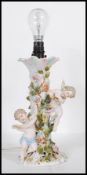 A 20th Century German porcelain Sitzendorf table lamp encrusted with florals and winged cherubs, one