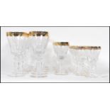 A large collection of glassware having scrolled decoration to the bowls raised on knopped columns on
