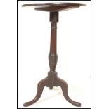 A 19th Century Georgian pedestal wine table having a round top raised on a central knopped column