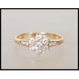 A stamped 585 14ct gold ring having a flower head set with seven white stones and accent stones to