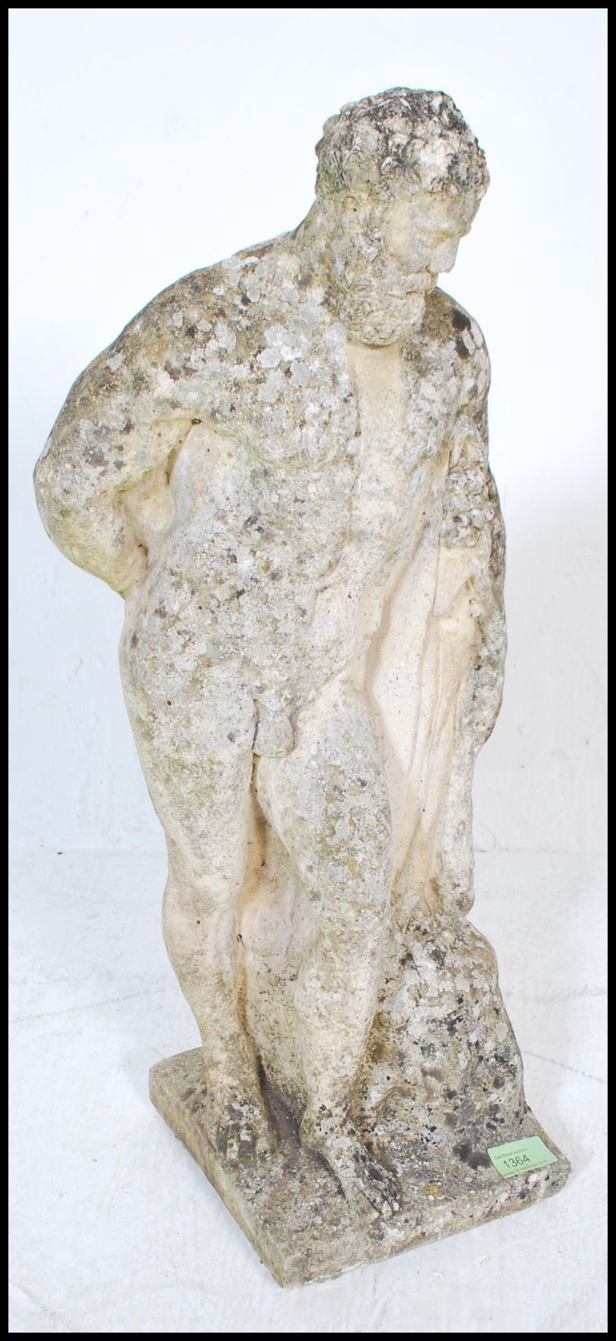 A 20th Century well weathered reconstituted stone garden statue figure of Hercules, leaning