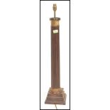 An early 20th Century mahogany table lamp having a reeded column with a gilt twist design panel to