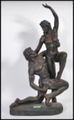 Two contemporary composite figurines of naked lovers, the first of a naked female held aloft