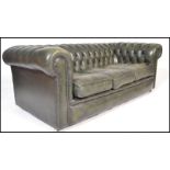 A 20th Century green leather upholstered chesterfield three seater sofa, having buttoned rounded