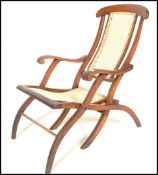 An early 20th Century campaign folding steamer chair of beech construction having caned backrest and