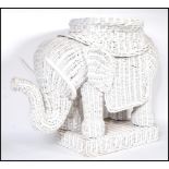 A retro 20th Century whicker work planter modelled as an elephant, the elephant set to a square base