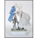 A Royal Copenhagen porcelain figurine depicting a Georgian couple kissing on a plinth base. Marks to