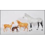 A group of four Beswick horses to include a large gray and white stallion with black hooves, two