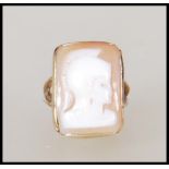 A hallmarked 9ct gold ring set with a carved rectangular cameo to the head depicting a roman