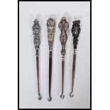 A group of three early 20th Century silver hallmarked button hooks. Each one having a silver