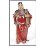 A stoneware figure of Chinese warrior decorated with sang de boeuf glaze with light green