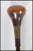 An early 20th Century walking stick cane having a white metal collar and a turned wooden knop.