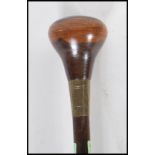 An early 20th Century walking stick cane having a white metal collar and a turned wooden knop.