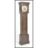 A 20th Century panel oak cased grandmother clock. The trunk with geometric carved embellishments,