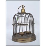A Victorian-style brass bird cage, being of cylindrical form with domed top having a suspension ring