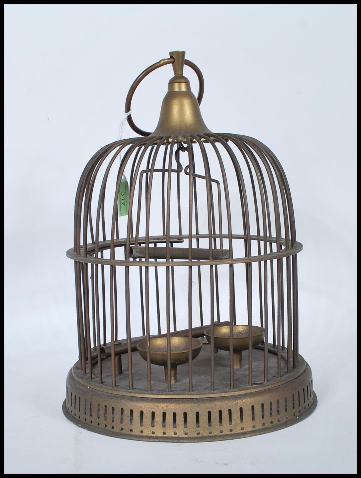 A Victorian-style brass bird cage, being of cylindrical form with domed top having a suspension ring