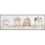 A group of four Staffordshire porcelain pastille burners in the form of cottages and being hand