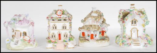 A group of four Staffordshire porcelain pastille burners in the form of cottages and being hand