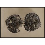 A 20th Century filigree belt buckle in a layered floral design having a hook and eye closure. Marked