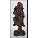 An early 20th Century Chinese carved hardwood figure of an Immortal holding a gnarled staff with one