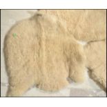 A collection of three 20th Century retro vintage sheepskin fleece floor rug carpet mats each natural