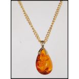 A 9ct gold necklace chain having an amber drop shaped pendant, along with a pair of amber cabochon