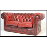 A 20th Century Oxblood leather upholstered chesterfield two seater sofa, having buttoned rounded