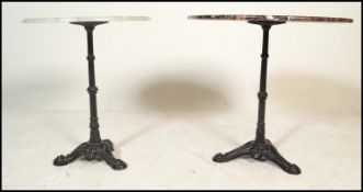 A pair of matching cast metal pedestal garden / pub tables dating to the first half of the 20th