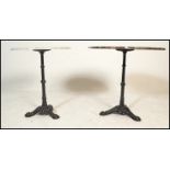 A pair of matching cast metal pedestal garden / pub tables dating to the first half of the 20th