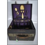 A early 20th Century fitted silver vanity set consisting of two bone handled brushes and silver