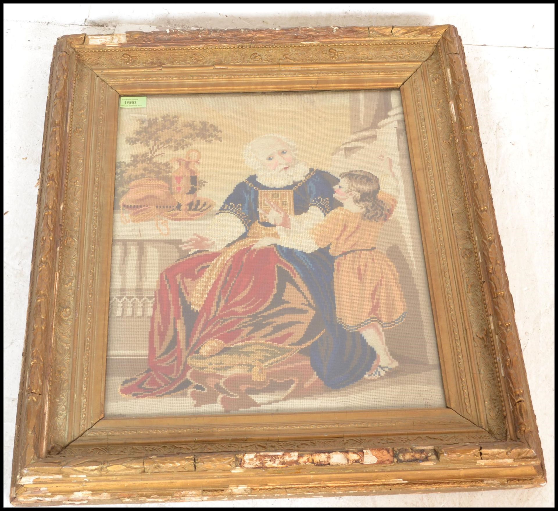 A 19th Century framed and glazed needlework tapestry depicting a seated religious gentleman beside a